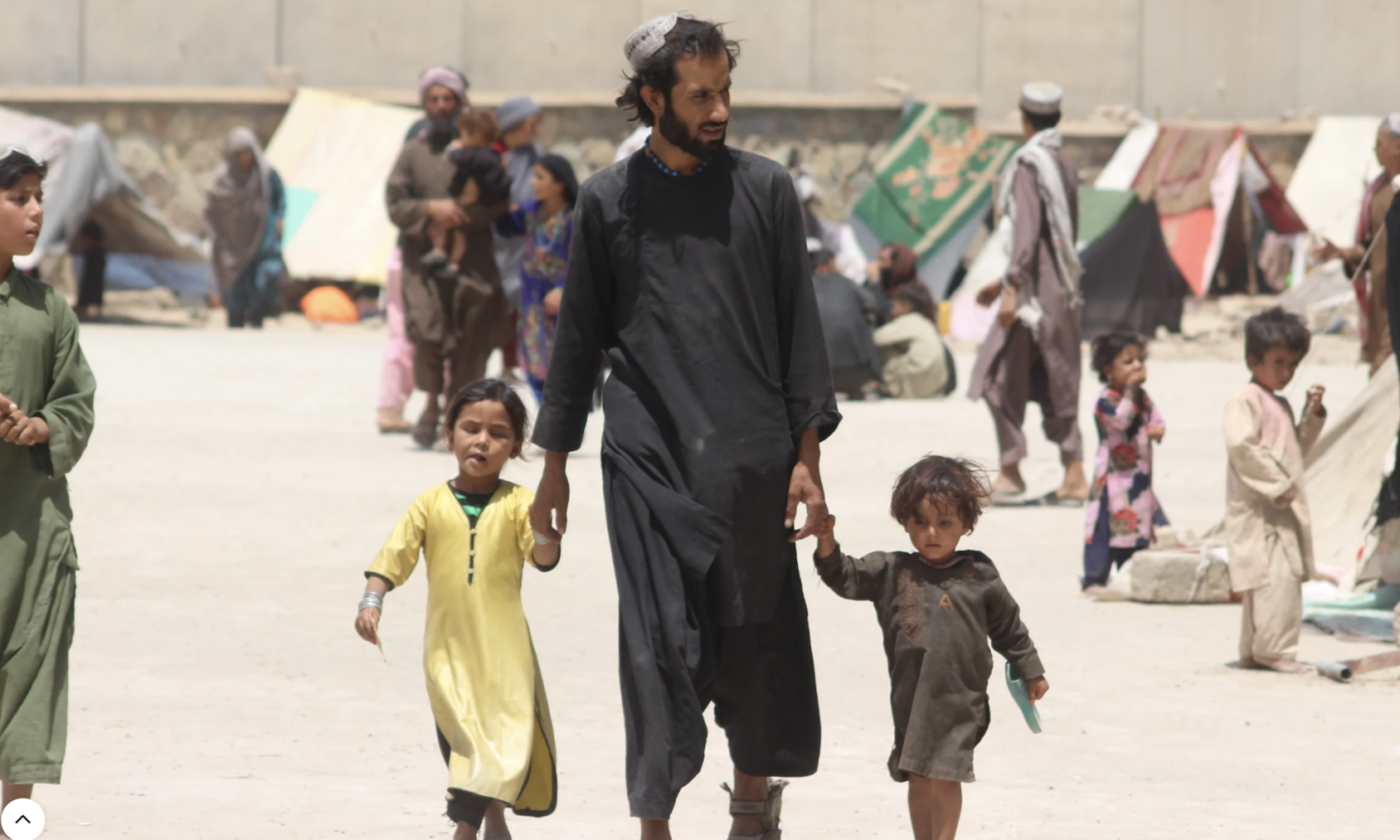 رجل يمشي يدًا بيد مع ولدين.