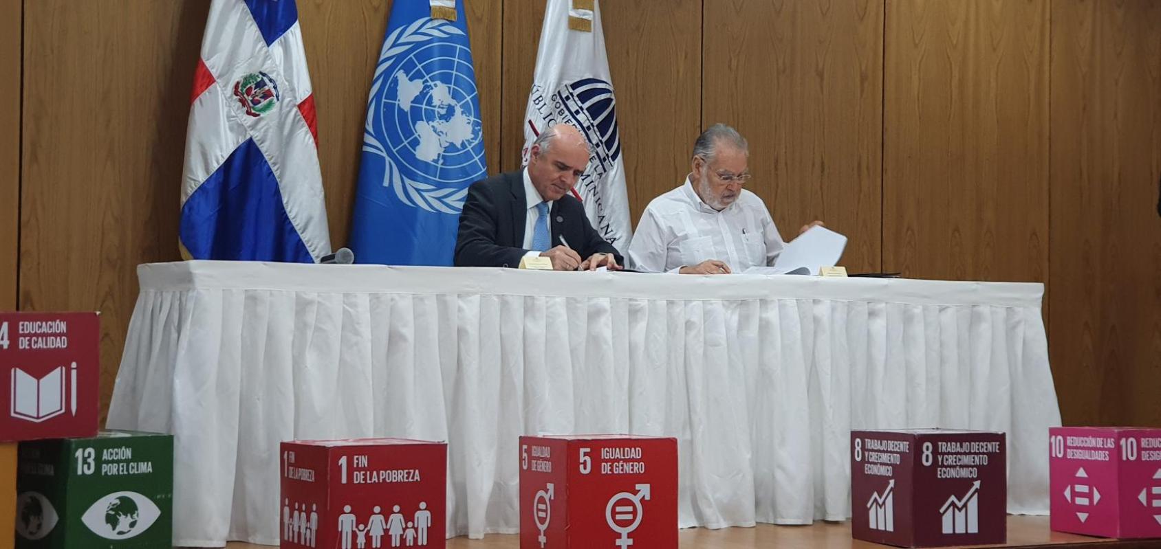 المنسق المقيم للأمم المتحدة في الجمهورية الدومينيكية موريسيو راميريز فيليجاس (إلى اليسار) مع وزير الاقتصاد والتخطيط والتنمية ميغيل سيارا هاتون (إلى اليمين) خلال توقيع اتفاقية التعاون الجديدة.