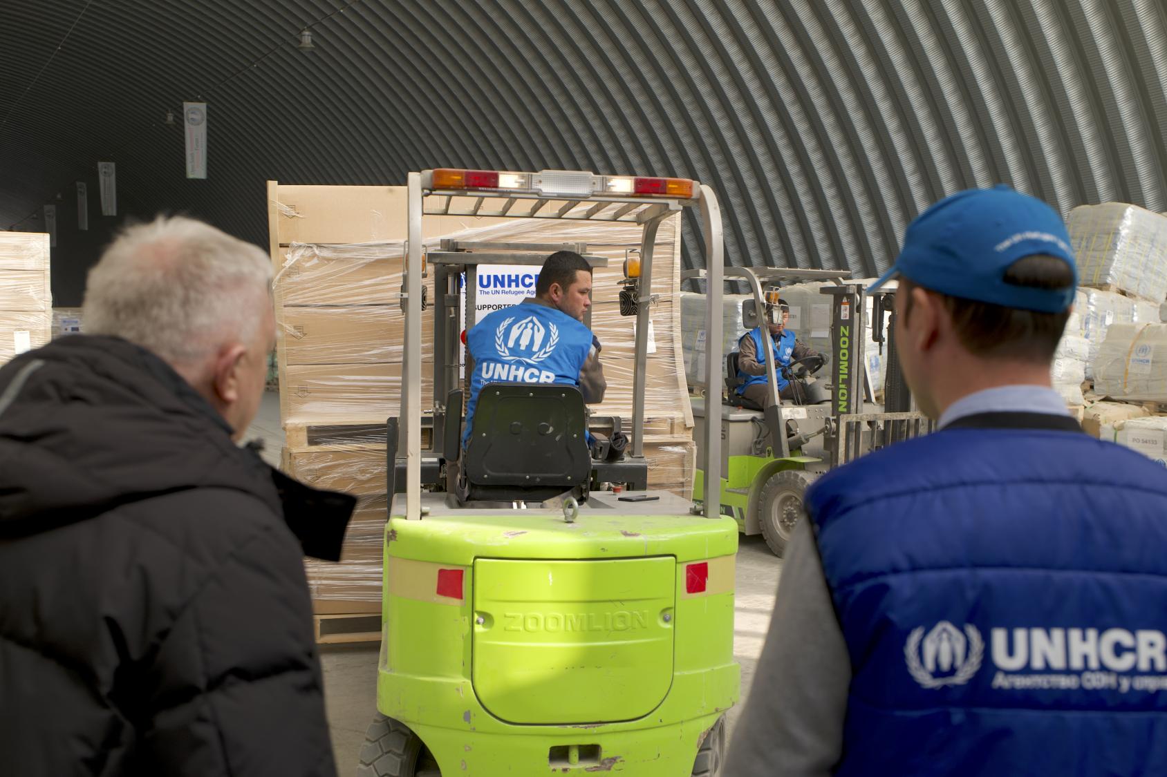 Logistics officers from UNHCR Central Asia move pallets of aid at the Termez Regional Humanitarian Logistics Hub in Termez, Uzbekistan 