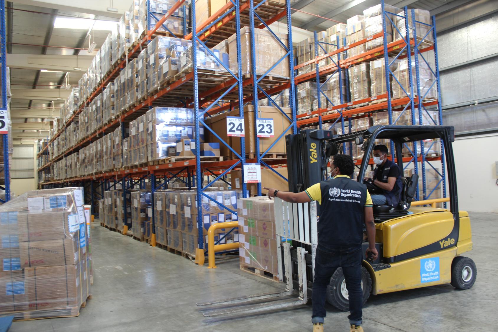 WHO logistics staff preparing emergency health supplies for dispatch.