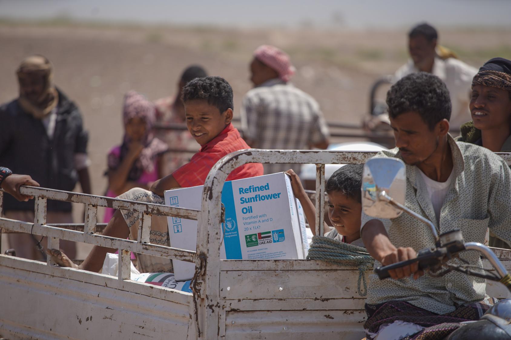 Familias recogen la ayuda alimentaria del PMA en Lahj, Yemen.