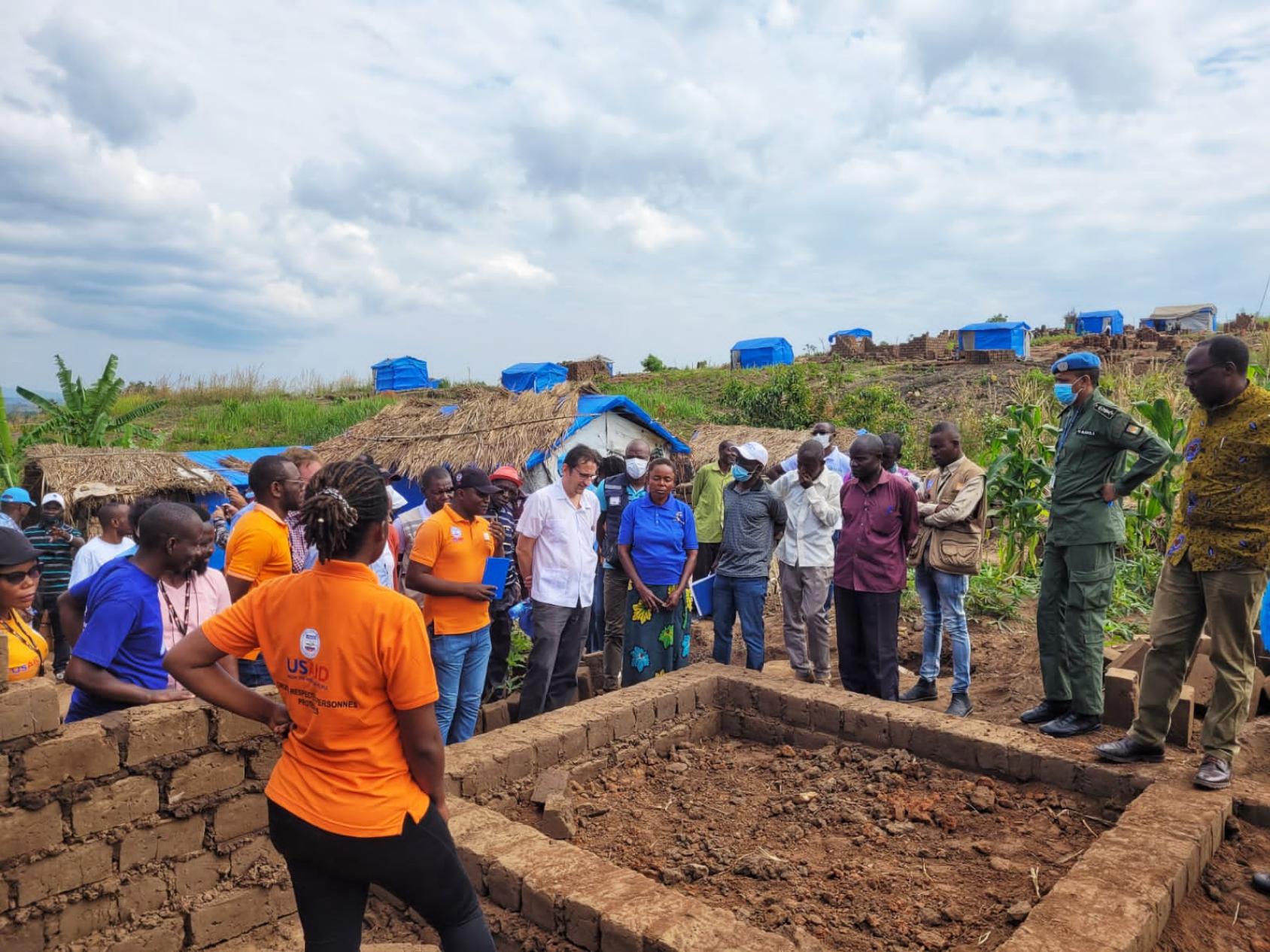 The Resident and Humanitarian Coordinator stands with a group of colleagues at the Tabac Congo IDP site in Kalemie, Tanganyika Province in June 2022. 