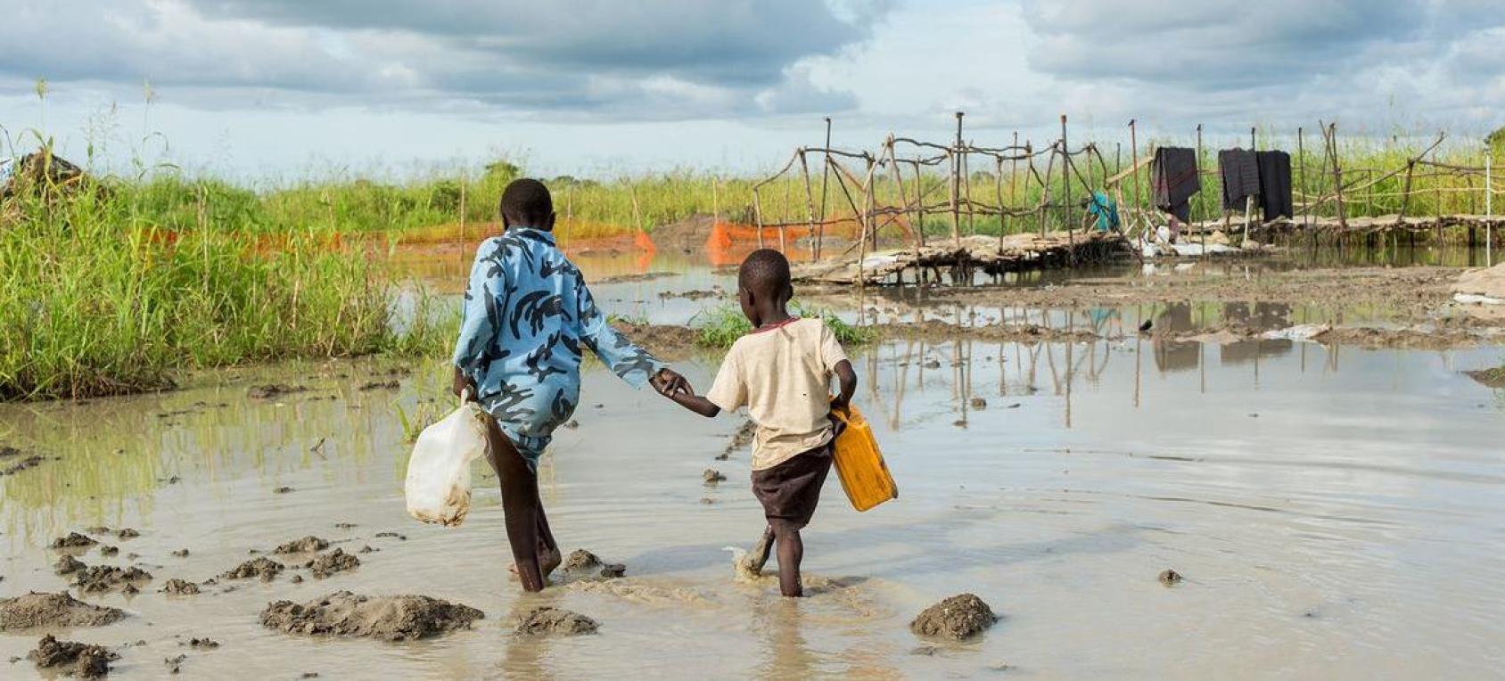 Des enfants marchent dans une zone inondée au Soudan du Sud.