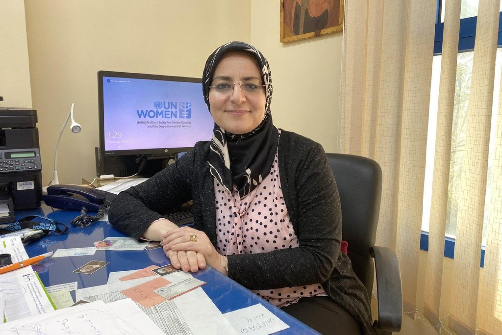 صورة لهبة الزيان، مديرة مكتب هيئة الأمم المتحدة للمرأة في قطاع غزة، تجلس على مكتبها