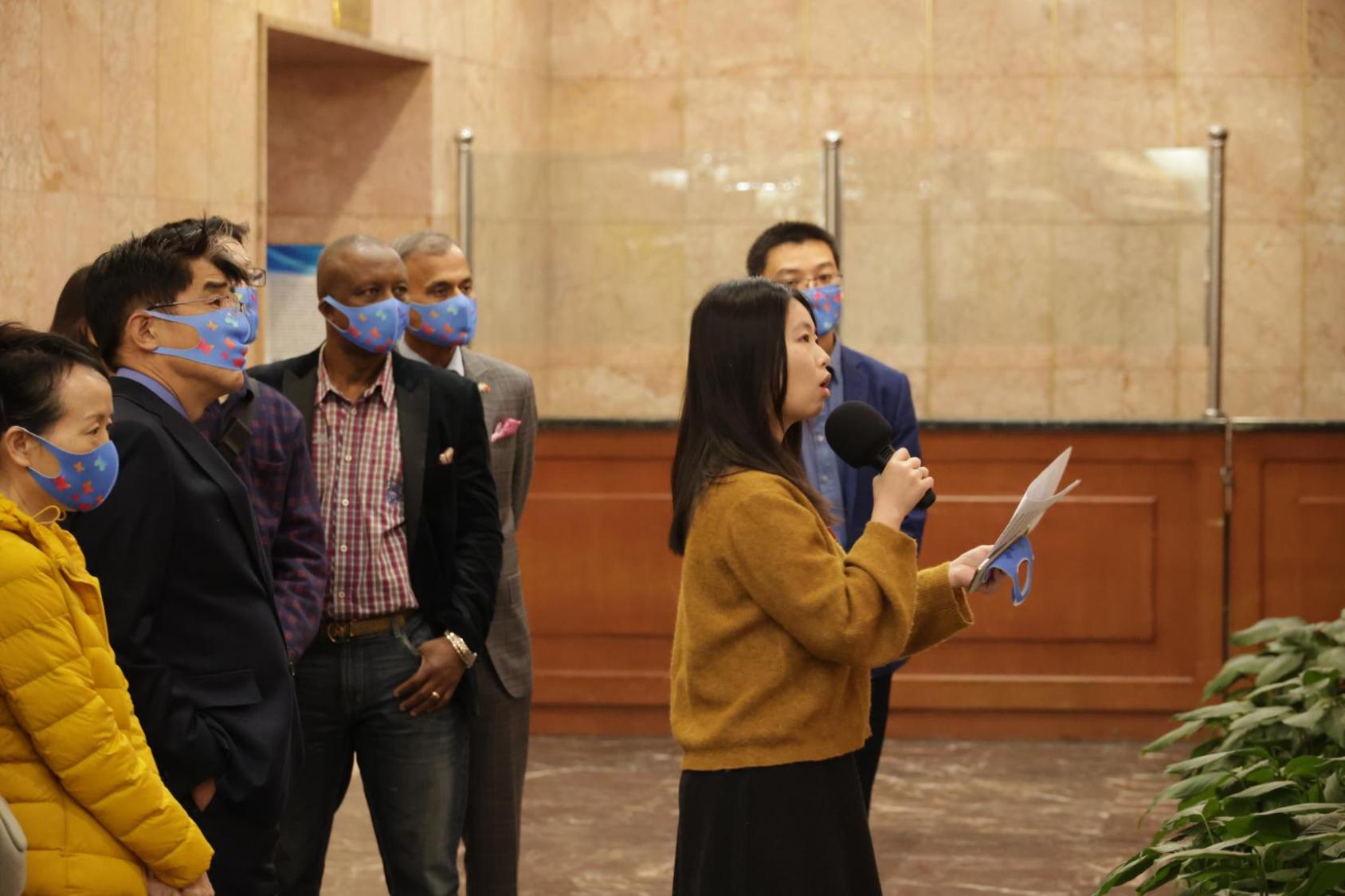 Weng Huiling (al frente, con un micrófono) guía un tour de exposición con motivo del Día de la Cero Discriminación.