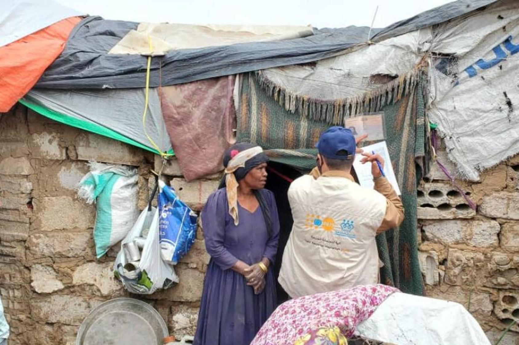 Una mujer desplazada por las inundaciones repentinas de agosto habla con el personal del UNFPA fuera de su refugio temporal en Marib, Yemen.