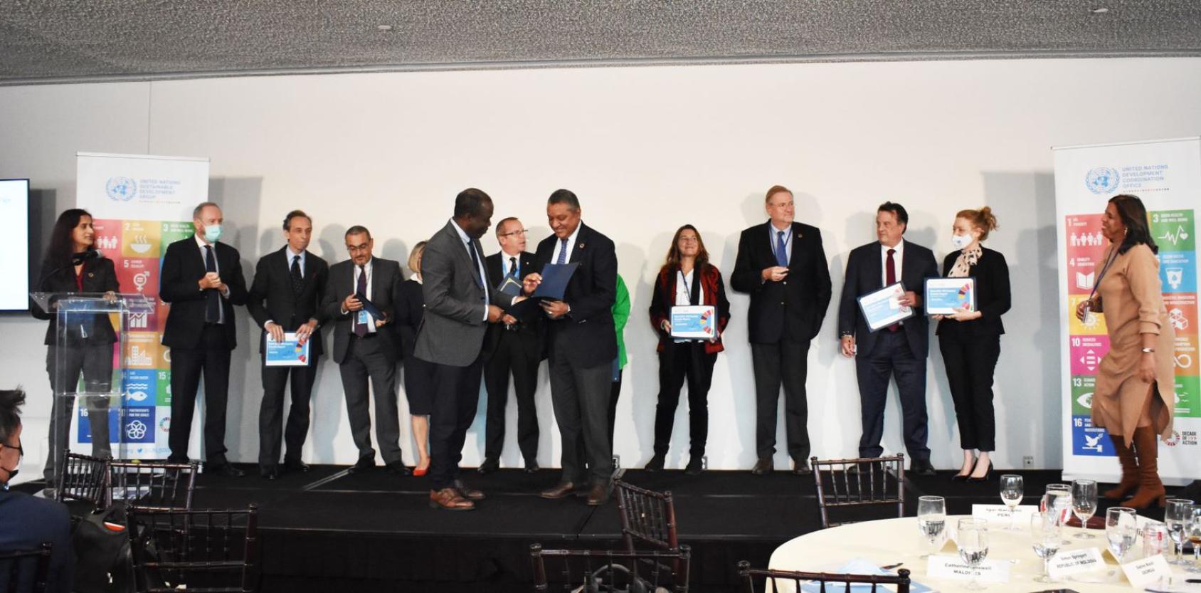 Plusieurs hauts dirigeants de l'ONU, femmes et hommes, se tiennent debout sur une scène lors de la cérémonie de remise des prix des meilleurs rapports annuels sur les résultats des équipes de pays des Nations Unies.