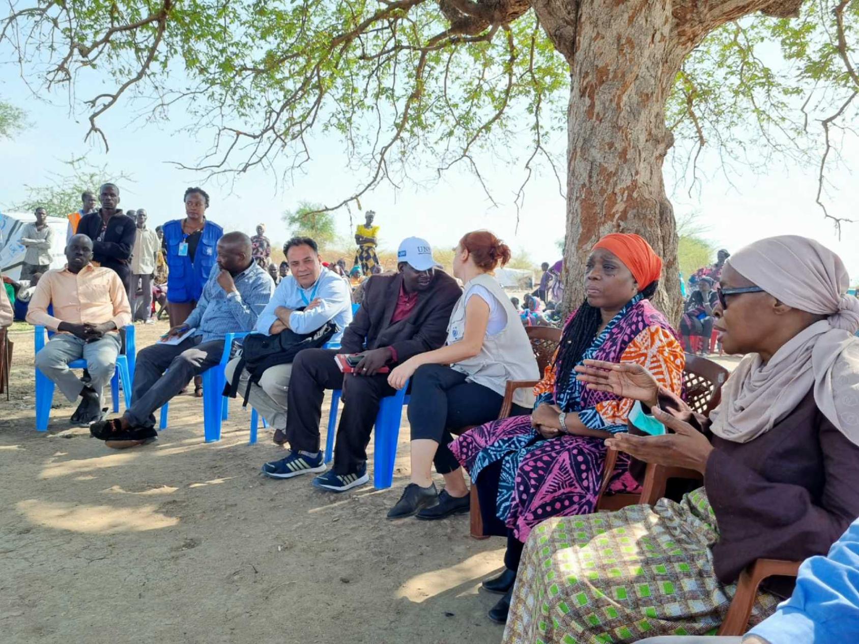 En un espacio exterior, las Coordinadoras Residentes hablan con representantes de las comunidades de desplazados internos de Abyei en junio de 2022.