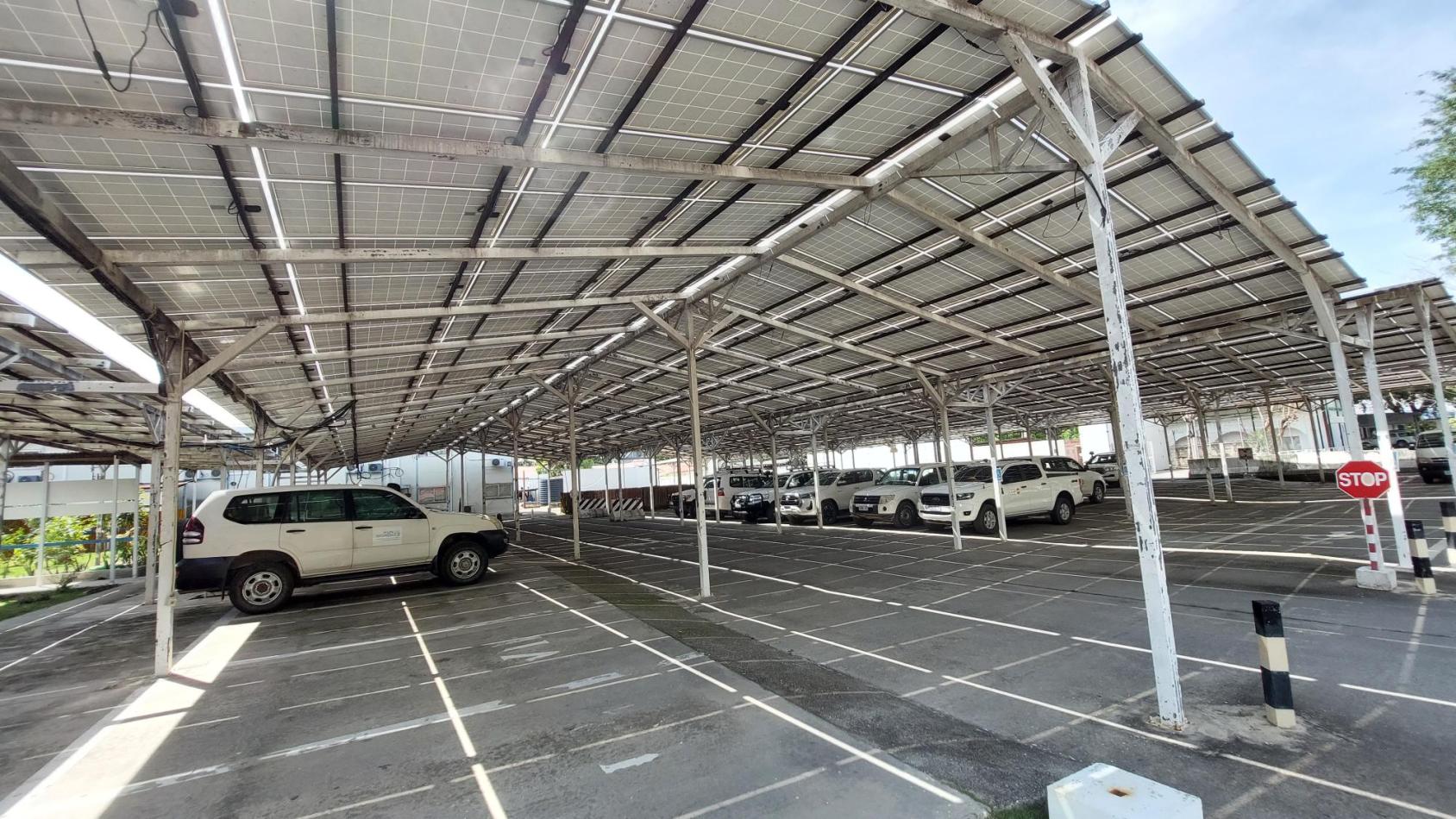 Large car park with solar panels above and vehicles parked within
