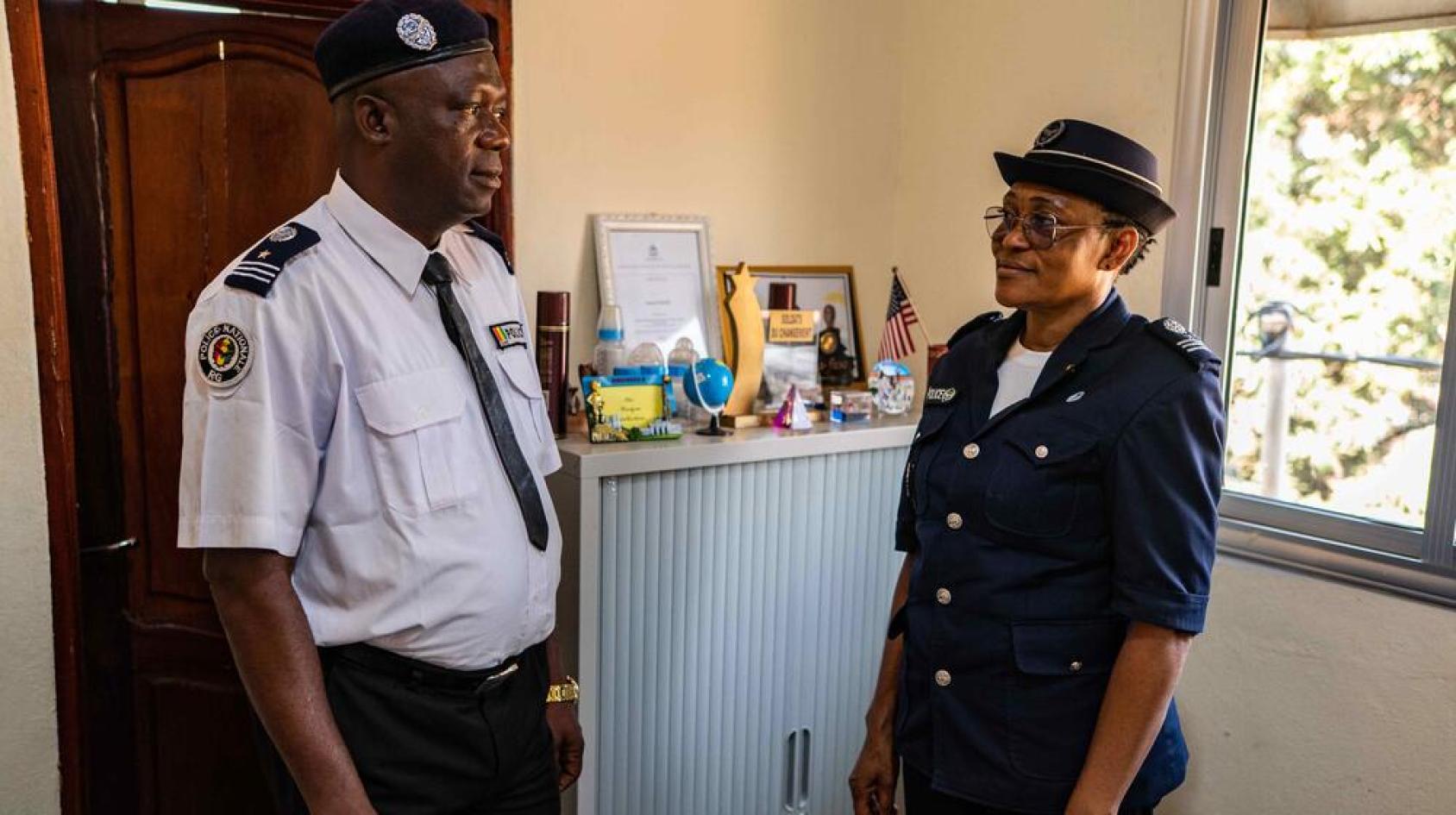 Two people, Marie Gomez and Sulla Amara, from Guinea, in officers' clothes standing in an office