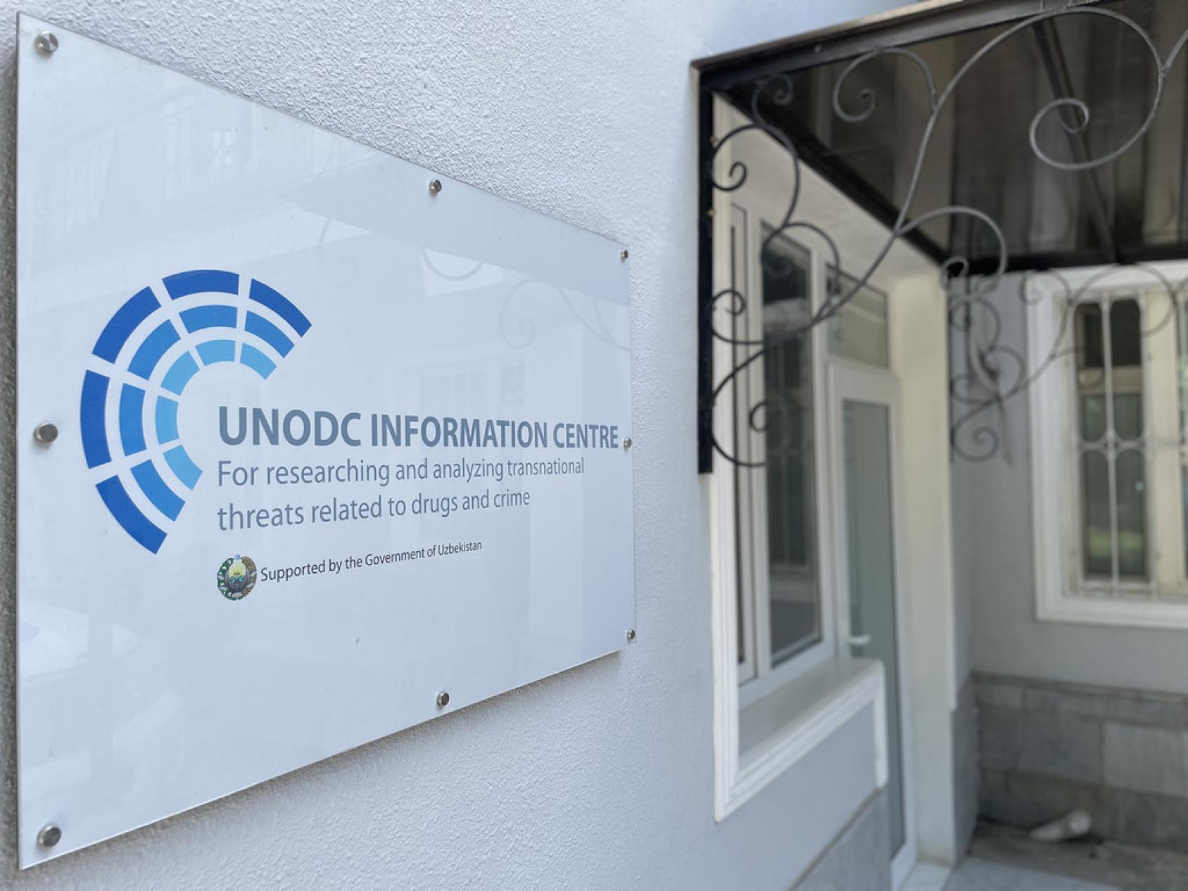 Табличка у входа в UNODC информационный центр на белой стене
