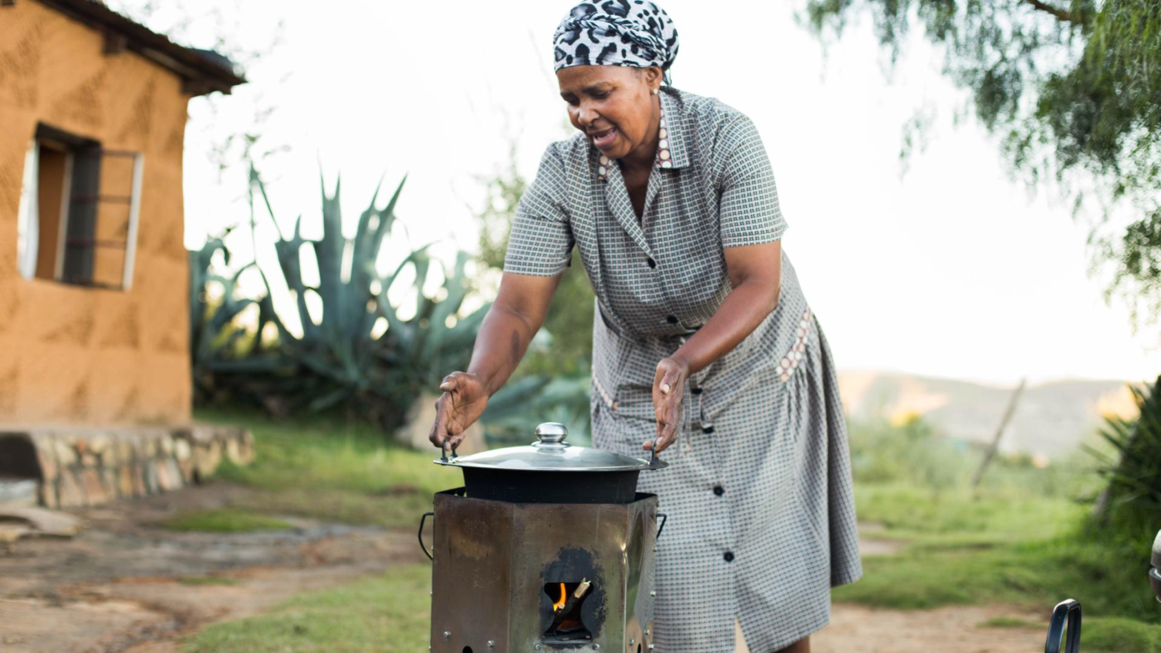 A woman cooks on a traditional stove