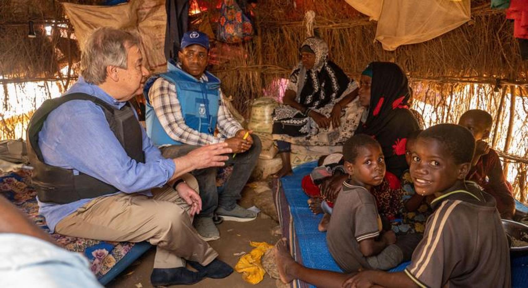 An official of the UN speaks to persons of concern in a tent.