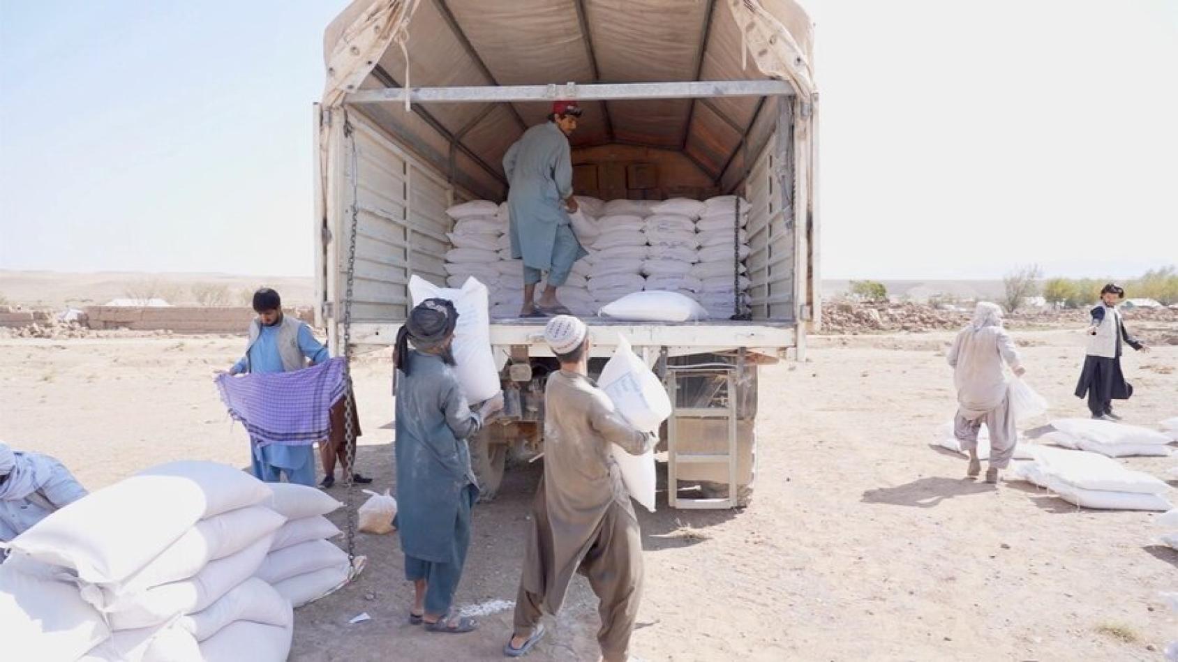 A group of men unload aid supplies from a truck in Herat, Afghanistan