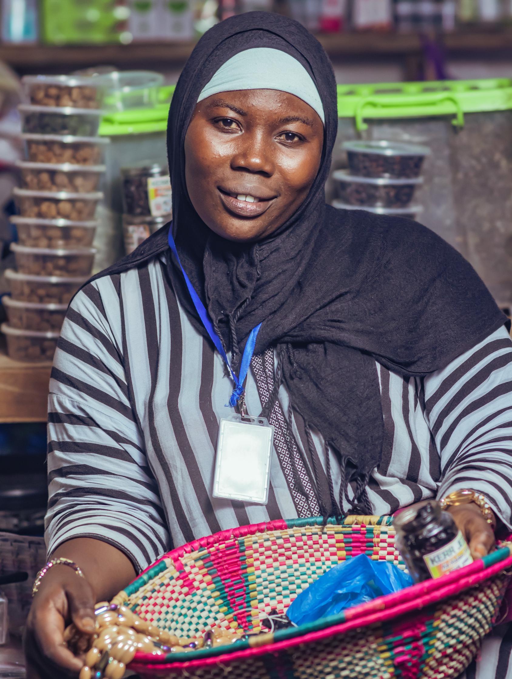 A woman in a black headscarf shows a pink basket