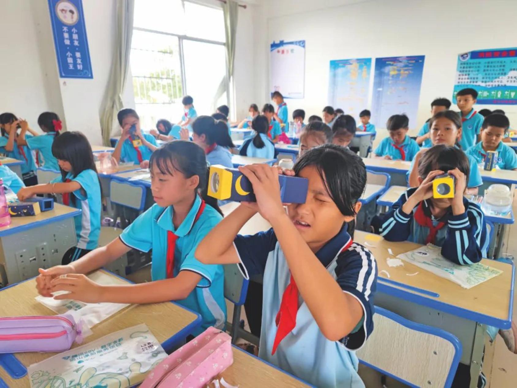  在中国海南省儋州农村的峨蔓中学，学生们在一位支教老师的帮助下制作万花筒。