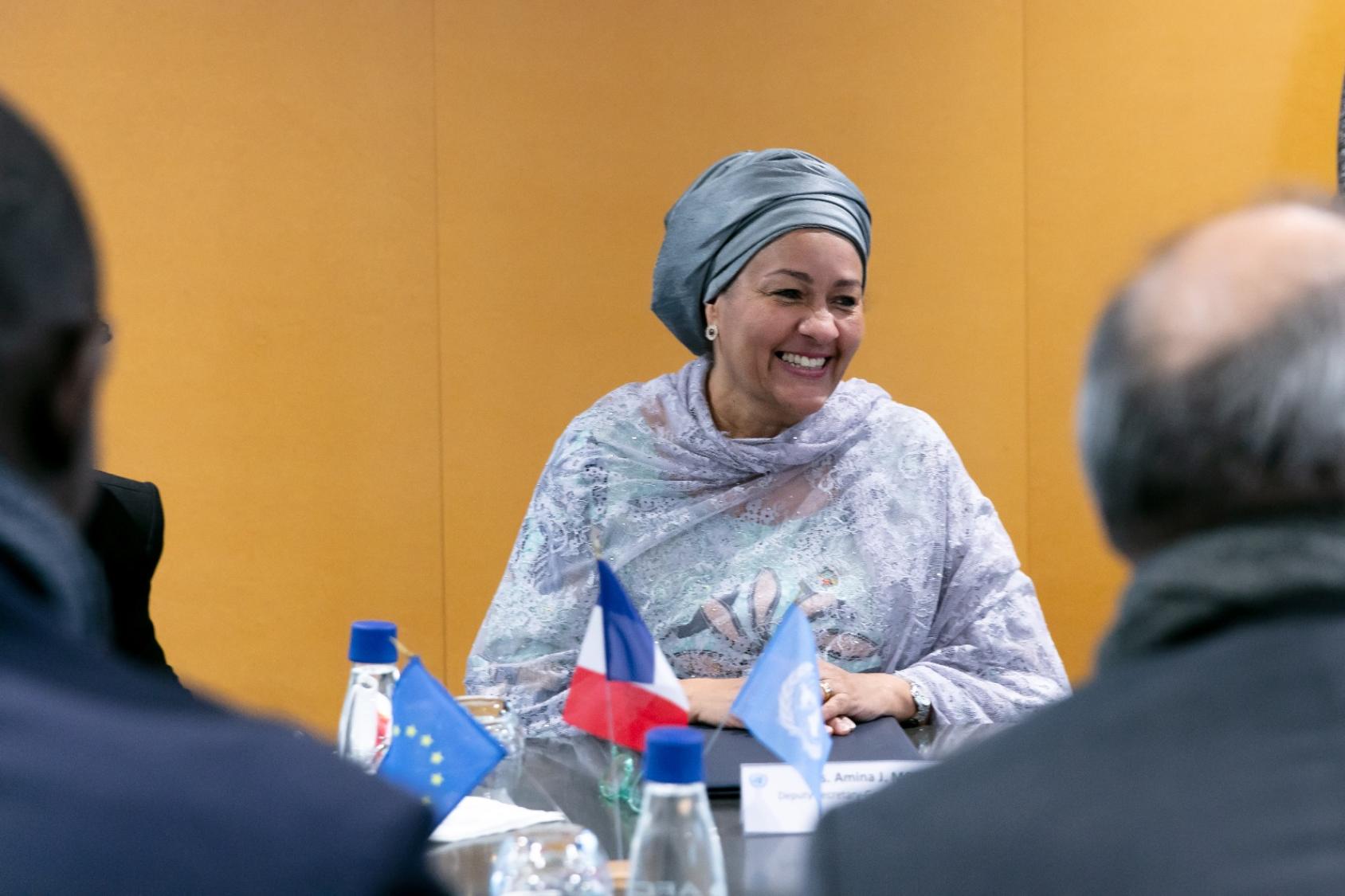 The UN Deputy Secretary-General wears a light colored wrap and talks to partners across a table at a strategic meeting.