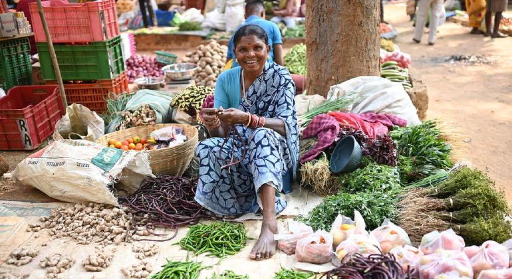 Индианка сидит на платке, с которого торгует травами и специями