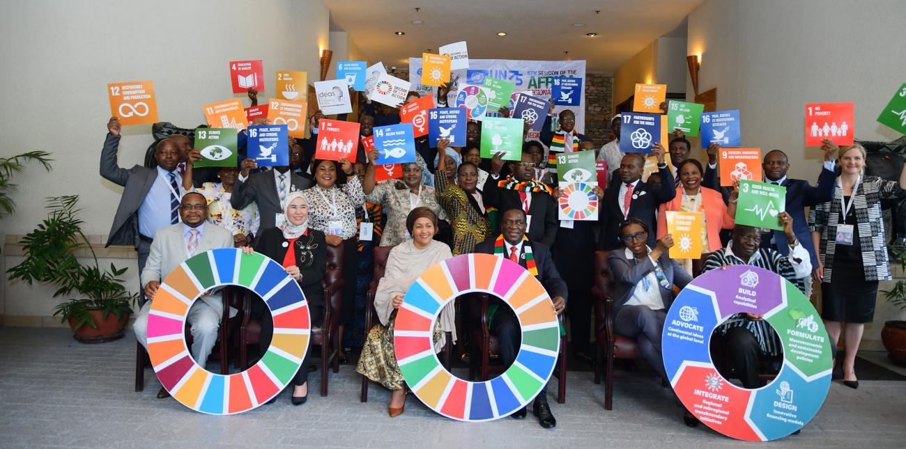 Shows DSG sitting with Resident Coordinators and colleagues holding SDGs signage.
