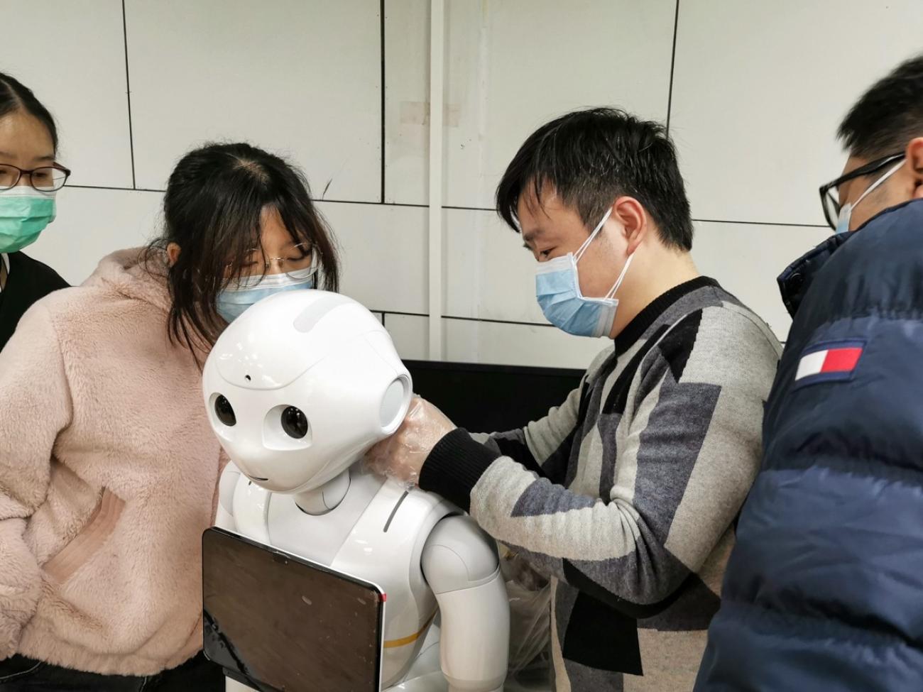 Shows youth handling a robot. Robots are used in many hospitals to deliver food, medicine and other supplies; to disinfect hospitals and other public areas to check patients’ temperatures and to answer common questions. 