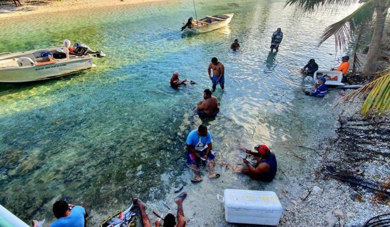 Shows people by the shore of the islands of Tokelau.