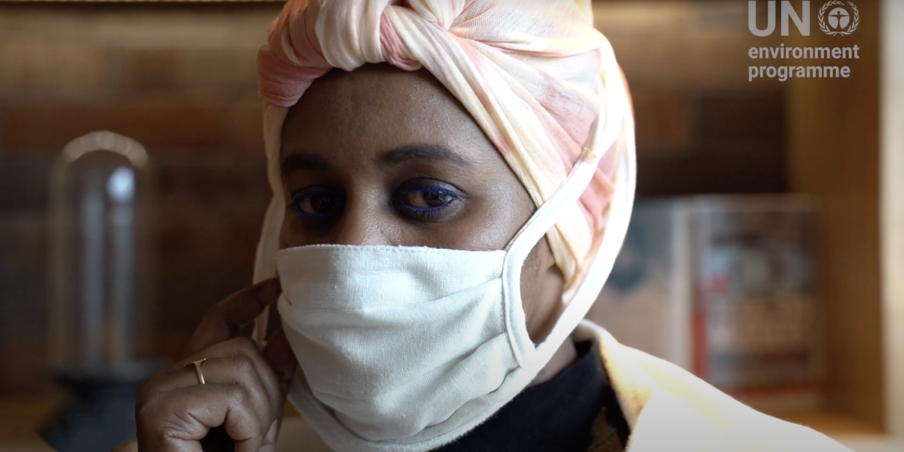 Capture d'écran de la vidéo produite par le PNUE montrant en gros plan la créatrice Nimco Ada portant un masque de protection et regardant la caméra.