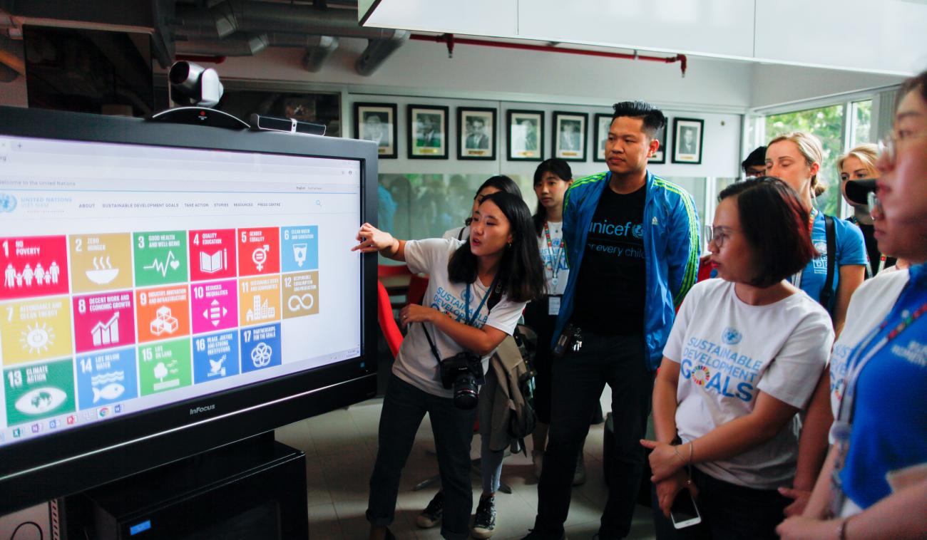 Con motivo del lanzamiento del nuevo sitio web del equipo de las Naciones Unidas en Viet Nam, varios miembros del equipo de la oficina del Coordinador Residente se encuentran reunidos frente a una pantalla. Una joven muestra a sus colegas las novedades del sitio.