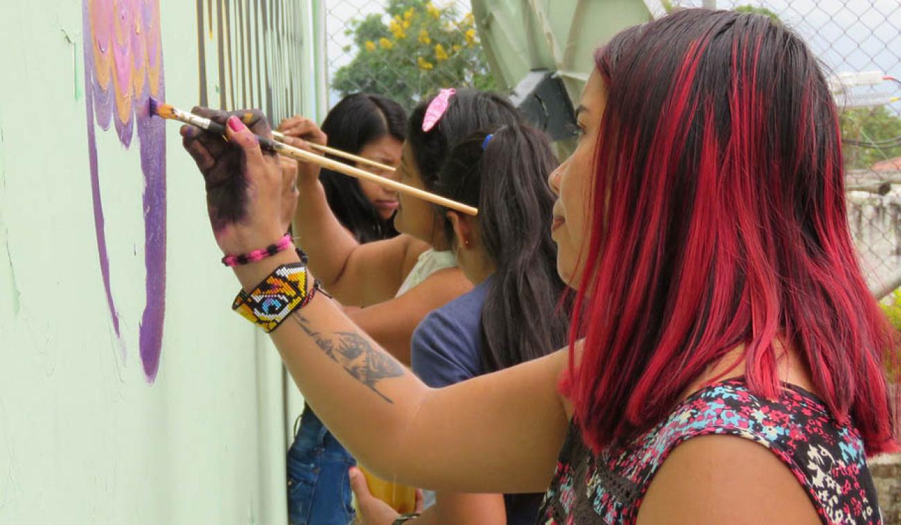 Women in Colombia decorate a wall with messages of peace in the town of Monterredondo.