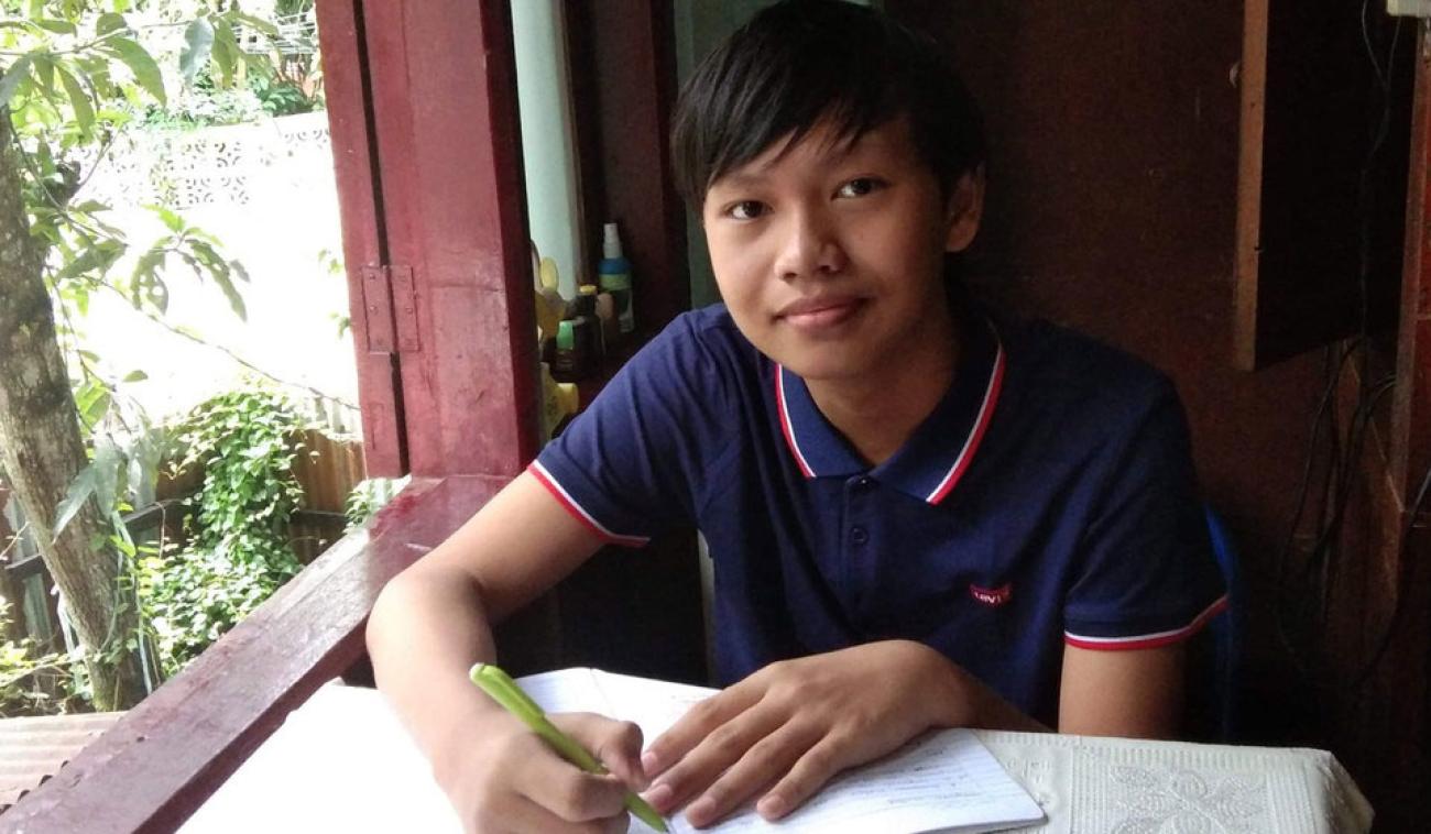 Thaw Lay, grade 10, from Yangon, Myanmar is shown studying at his home.