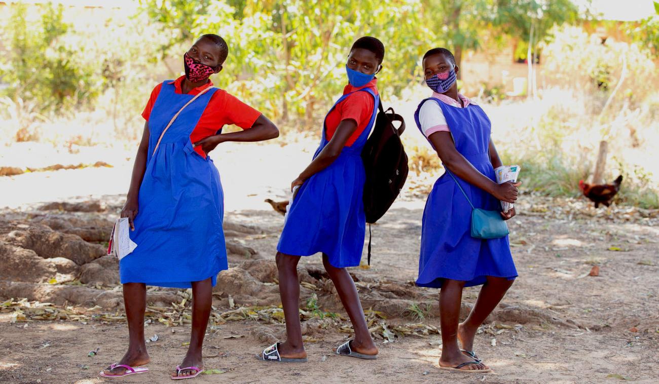 Three school girls having fun within the school campus at Luwambaza primary school