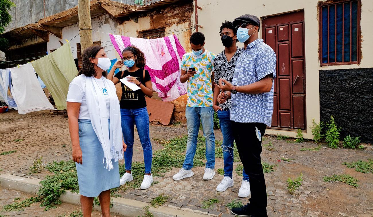 Resident Coordinator, Ana Patricia Graça, speaks outside a neighbourhood with young artists.