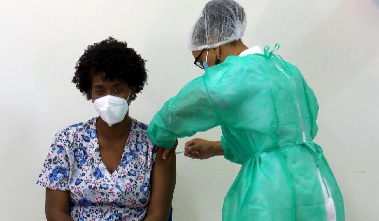 Ana Manuela, una técnica de salud, se sienta con tranquilidad, mientras recibe la vacuna contra la COVID-19.