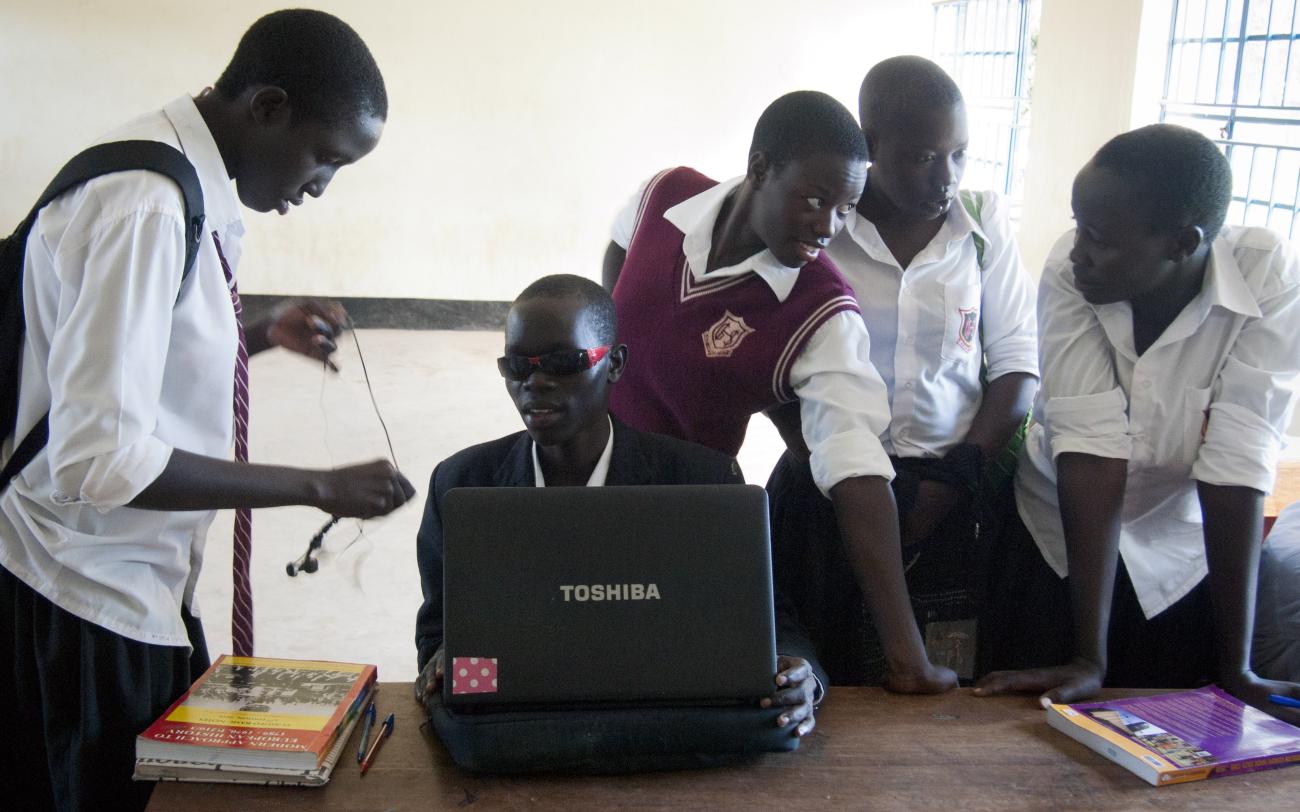 يجلس دينيس كوماكيتش، طالب كفيف يبلغ من العمر 17 عامًا، مع زملائه في الفصل أثناء تجهيز حاسوبه الخاص في مدرسة غولو الثانوية في شمال أوغندا.