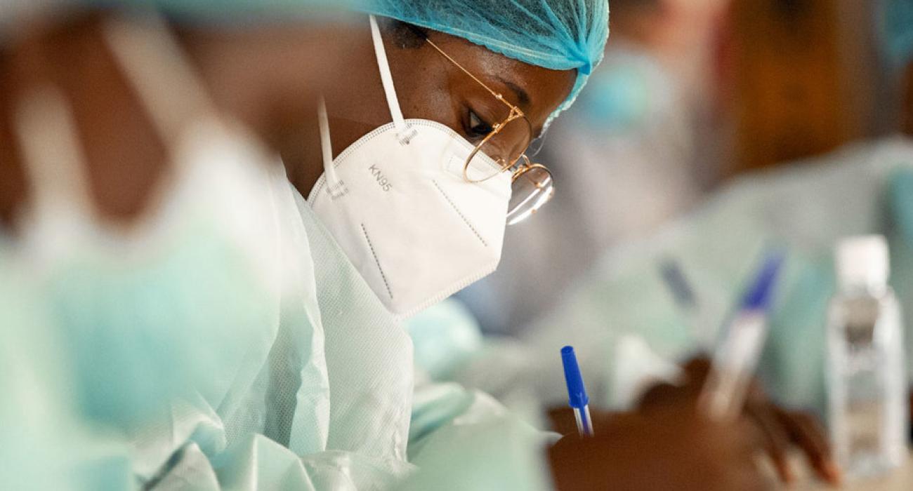 A close up of a healthcare working wearing protective gear as she writes notes. 