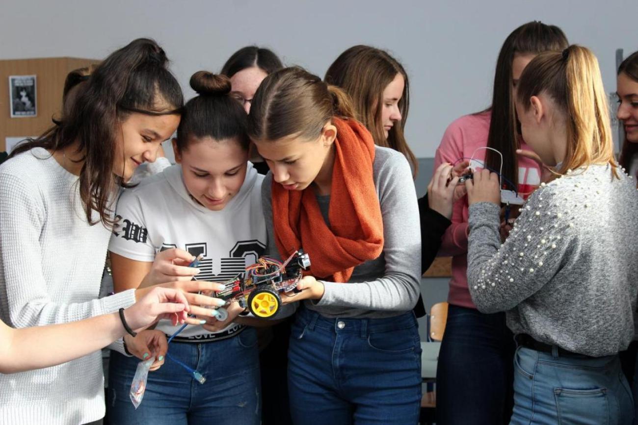 مجموعة من الطالبات يعملن على نموذج سيارة آلية.