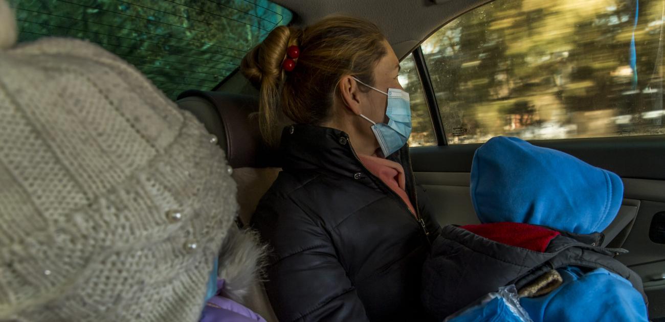 Roza Nurymova, 36, and two of her children ride in a taxi after visiting the office of Sana Sezim.