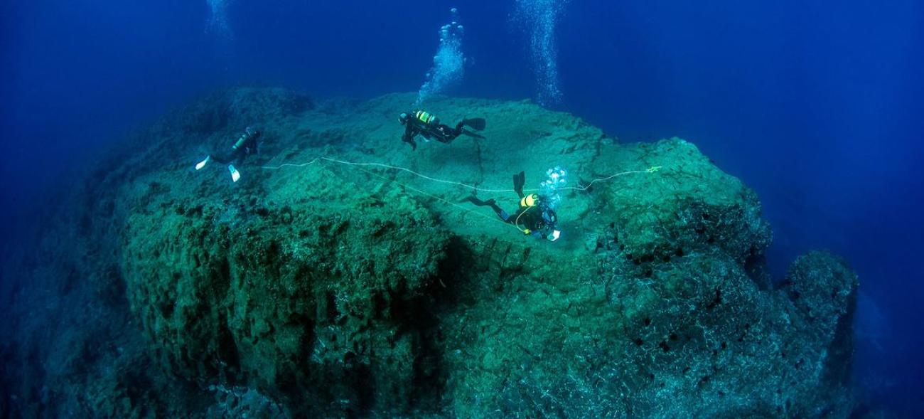 一组科学潜水员在葡萄牙马德拉港圣港的海底评估海洋生物多样性。