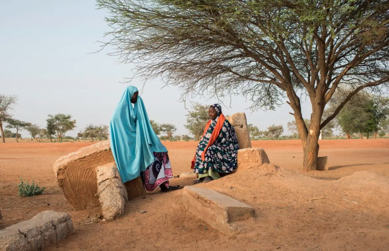 Hamsou Mohamat (à gauche), une habitante de la région, discute avec Jamilla Oumaru, une réfugiée nigériane, à Garin Kaka, un « village d'opportunités » soutenu par le HCR dans le centre-sud du Niger.  © HCR/Colin Delfosse