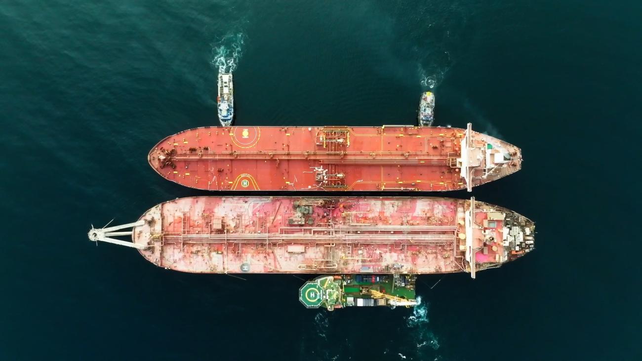 Two tanker ships, one older and rusting, stand next to each other in the waters off Yemen's coast
