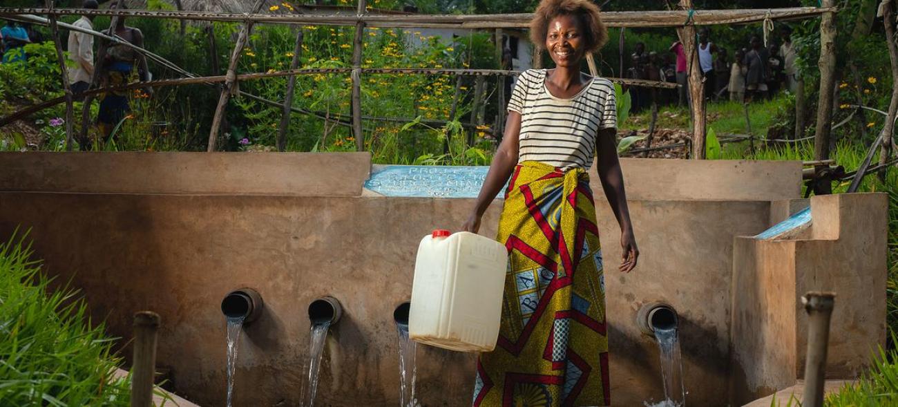 Una mujer recoge agua de una fuente desarrollada por UNICEF en la provincia de Kasai, R.D. Congo.