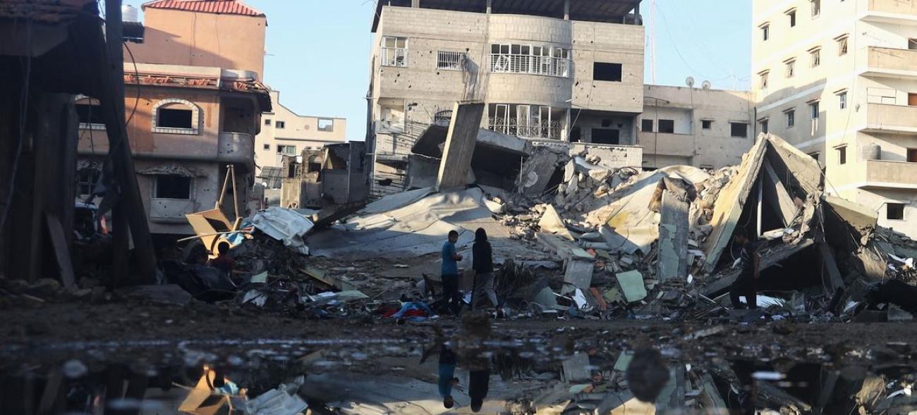 Двое мужчин на обломках разрушенные здания в ходе бомбежек в городе Рафах, сектор Газа.