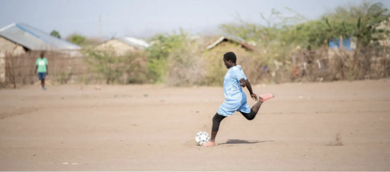 维纳斯足球俱乐部和皇后区足球俱乐部的女运动员们在肯尼亚卡库马难民营参加 2022 年世界难民日庆祝活动的足球友谊赛。