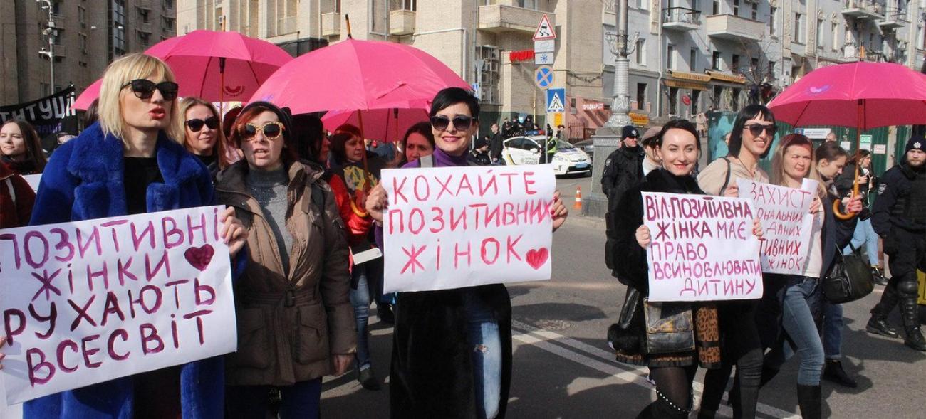 Женщины стоят с плакатами на улице