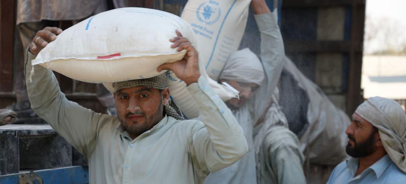 Мужчина с мешком муки на голове, гумантиарной помощью от WFP