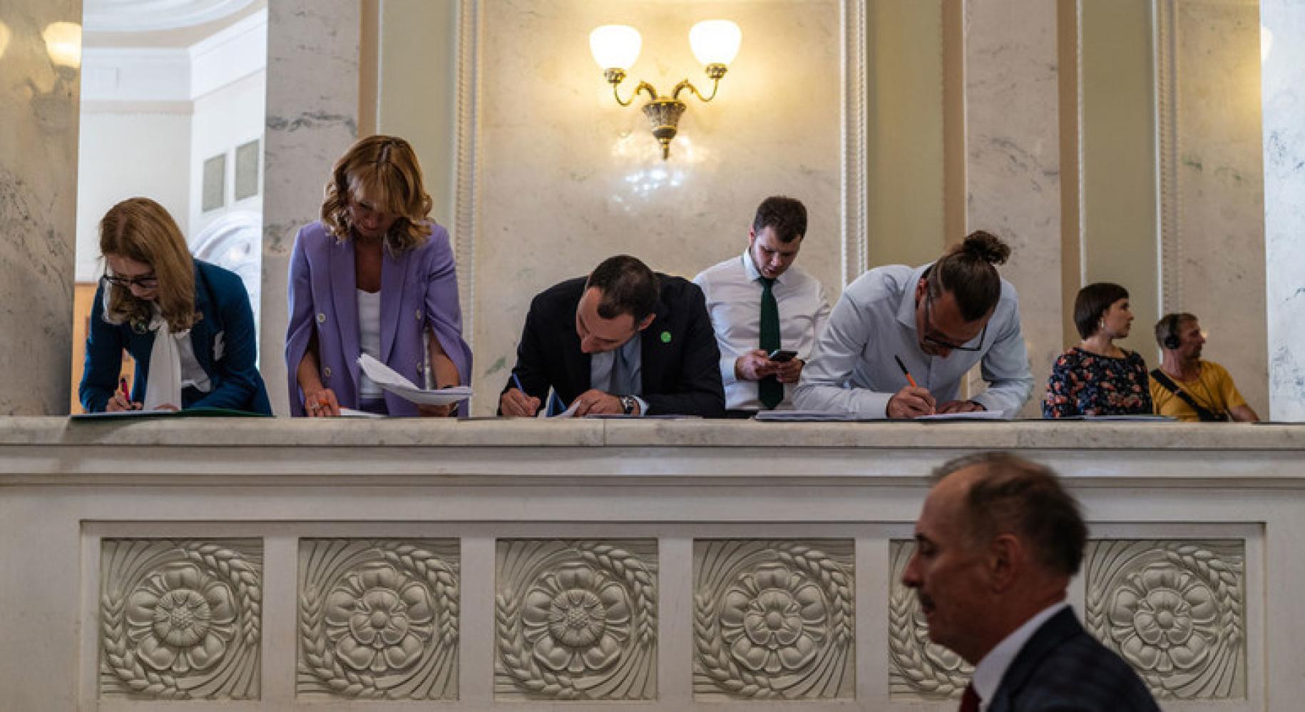 People signing documents in a formal setting