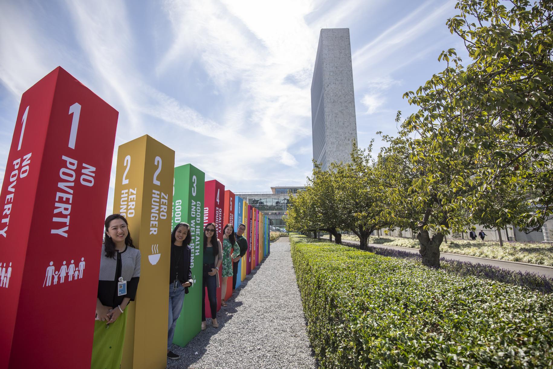 UN Staff members stand outside the SDG Action Zone by SDG pillars.