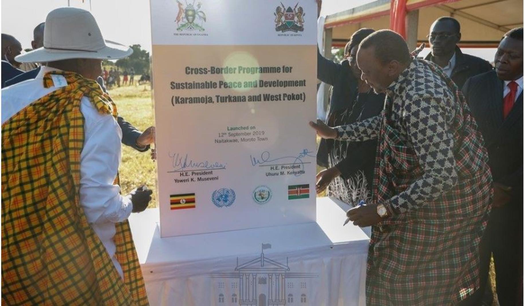 The two country presidents (Kenya and Uganda) are shown signing a signage demonstrating their collaboration.