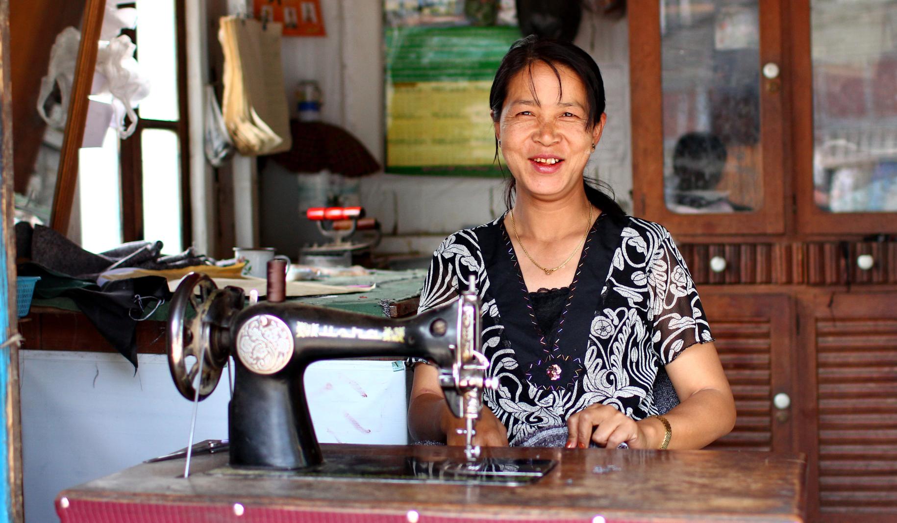 تستخدم خياطة دواسة القدم لتشغيل ماكينة الخياطة الخاصة بها في ميانمار.