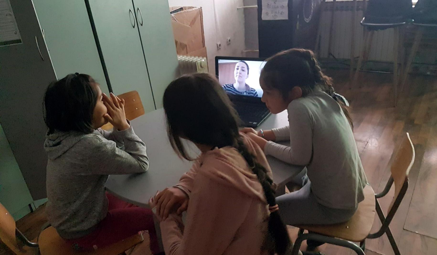 Three young female students participate in an online class.