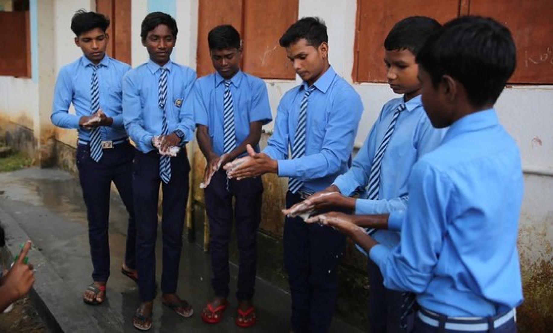 Alumnos de una escuela de Chhattisgarh, en el noreste de la India, practican técnicas seguras de lavado de manos.